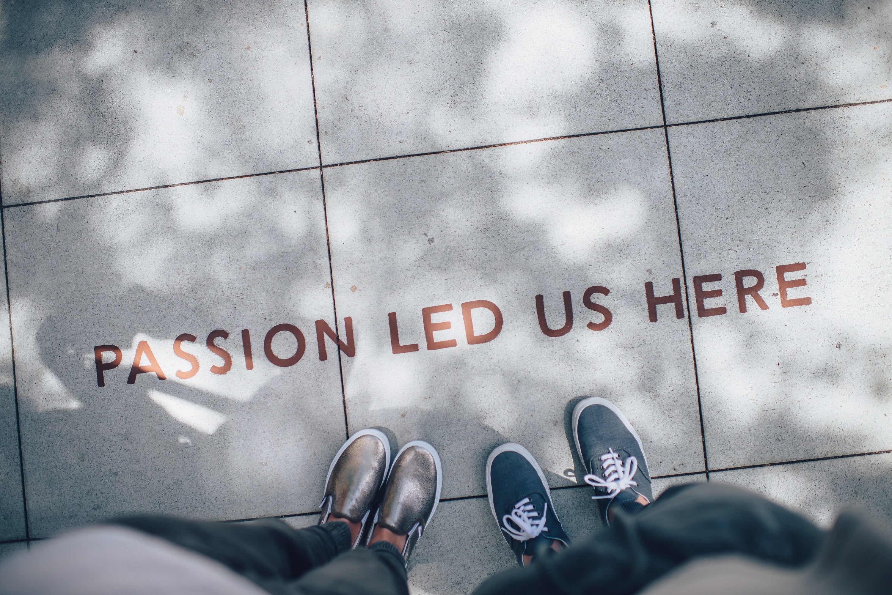 Intrinsische Motivation: Aufschrift “Passion led us here” auf Boden